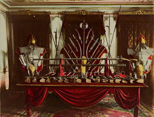 Armi e armature esposte all’interno del Palazzo Yildiz. In primo piano viene presentata una selezione di armi da fuoco. Fonte: İstanbul Üniversitesi, Head Office of Library and Documentations. Weapons and armor displayed inside Yildiz Palace. In the foreground, a selection of firearms is presented. Source: Istanbul University, Head Office of Library and Documentation.