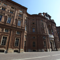 La facciata di Palazzo Carignano fu realizzata su disegno di Guarino Guarini nella seconda metà del Seicento. L’elegante sinuosità esprime la concezione barocca guariniana, sottolineata da decorazioni murali in mattone. Successivo è il fastigio che ricorda la nascita del primo re d’Italia Vittorio Emanuele II, avvenuta nel Palazzo il 14 marzo 1820.