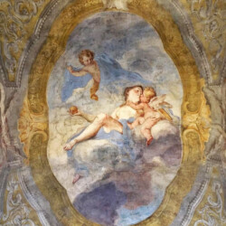 L’affresco può essere ammirato sulla volta del corridoio dell’Appartamento di Mezzanotte, nell’ala del Palazzo dove hanno sede gli uffici della Direzione regionale Musei Piemonte.
La scena del tenero bacio tra Venere e Cupido fu eseguita dal pittore lombardo Stefano Maria Legnani, detto il Legnanino, insieme alla sua bottega, tra il 1695 e il 1698.