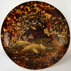 Il Castello di Agliè possiede una collezione orientale di circa centottanta pezzi, per lo più esposta nella Sala Cinese, che fu raccolta dal duca Tomaso di Savoia-Genova durante la spedizione sulla corvetta Vettor Pisani dal 1879 al 1881. Tra questi oggetti si conserva un grande piatto in carapace di tartaruga del diametro di 44 cm, opera di manifattura giapponese realizzata con la tecnica della lacca d’oro, “makie” letteralmente “pittura cosparsa”.