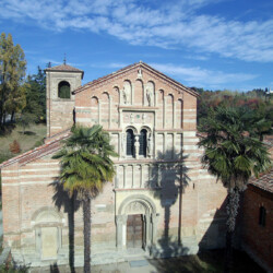 Foto di Beppe Chiodi<br>La Canonica di Santa Maria di Vezzolano, costruita a partire dalla seconda metà XII secolo e portata a termine nel XIV-XV secolo, sorge in una valle del Monferrato tra vigneti, prati e aree boschive. Prima di varcare la soglia, pellegrini e fedeli ammiravano la facciata a salienti in cotto con fasce orizzontali in arenaria, scandita da loggette cieche, ricca decorazione scultorea originariamente policroma e pregiati bacini ceramici a lustro metallico.