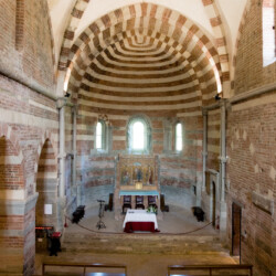 La Chiesa di Santa Maria di Vezzolano, costruita a partire dalla seconda metà del XII secolo, presenta una navata centrale scandita in tre campate da robusti pilastri di linguaggio romanico e volte a crociera costolonate di gusto gotico, ed è ritmata dall’alternanza cromatica del cotto e dell’arenaria. La monofora centrale dell’abside è arricchita da una decorazione scultorea del 1180 raffigurante l’Annunciazione della Vergine.