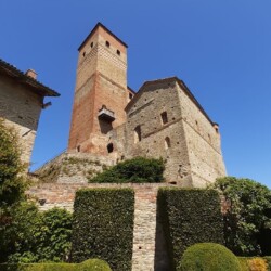 La torre quadrata trecentesca e un edificio di servizio, realizzato nel XV secolo a chiusura della corte interna, caratterizzano questo prospetto del Castello di Serralunga d’Alba. Il terrazzamento inferiore, recentemente sistemato a giardino, si compone di semplici aiuole verdi delimitate da siepi di bosso, con al centro alberi di melograno e contrafforti verdi addossati al muro.