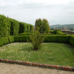 L’antico Castello di Serralunga, tra le suggestive colline del sito UNESCO dei paesaggi vitivinicoli, comprende spazi verdi, terrazzamenti e un giardino ‘alla medioevale’. Al suo interno si trovano alberi da frutta e viti rappresentative dei cinque vitigni DOC di Serralunga, insieme ad aiuole a prato, siepi e topiarie in bosso, modellati secondo un disegno eseguito nel 2001 su progetto di Renata Lodari e Federico Fontana. L’area include, inoltre, una scarpata arborata con presenza di olmi, robinie e arbusti.